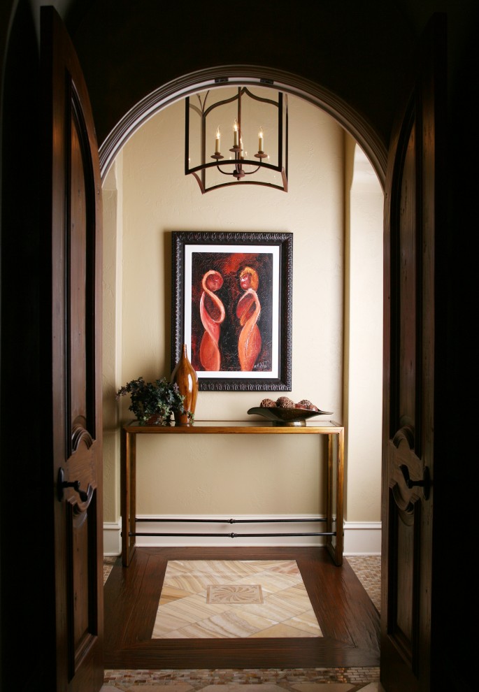 This is an example of an eclectic hallway in Orlando with beige walls, dark hardwood floors and multi-coloured floor.