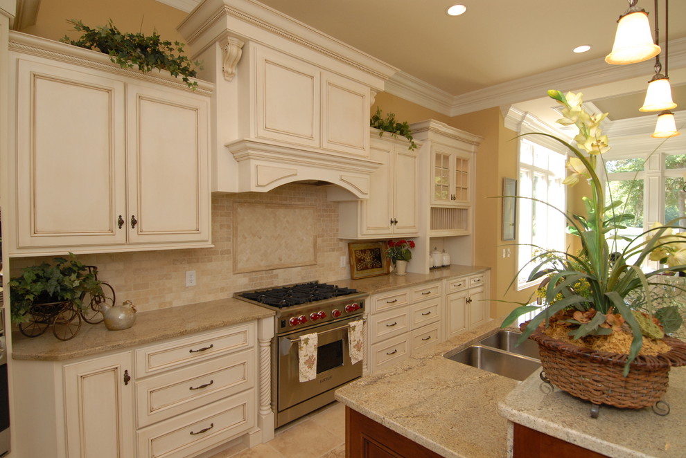 Photo of a large traditional u-shaped eat-in kitchen in Atlanta with white cabinets, beige splashback, stainless steel appliances and with island.