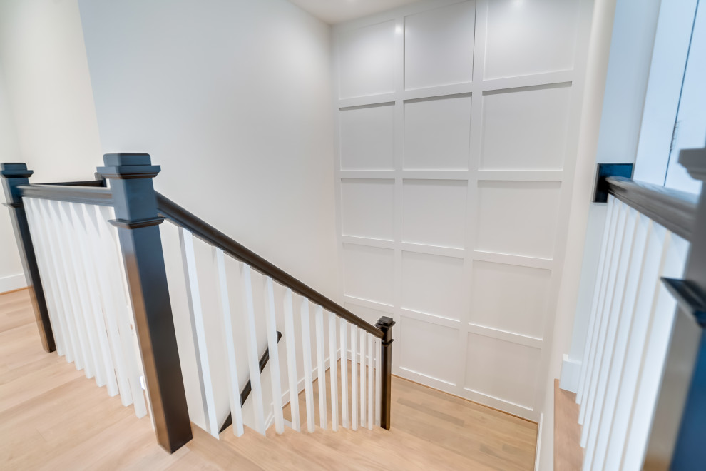 Photo of a large transitional staircase in DC Metro with decorative wall panelling.