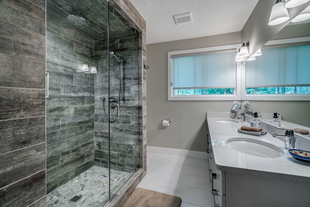 Design ideas for a mid-sized midcentury master bathroom in Calgary with shaker cabinets, white cabinets, an alcove shower, a one-piece toilet, multi-coloured tile, beige walls and an undermount sink.