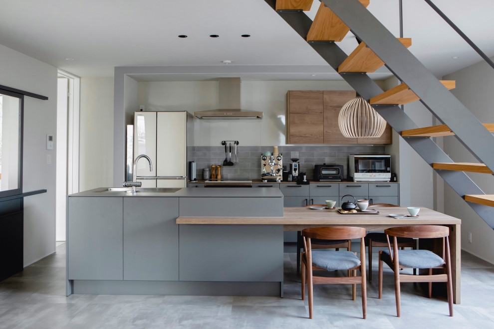 This is an example of a mid-sized asian single-wall open plan kitchen in Osaka with an undermount sink, open cabinets, grey cabinets, laminate benchtops, grey splashback, marble splashback, stainless steel appliances, cement tiles, with island, grey floor, grey benchtop and wallpaper.
