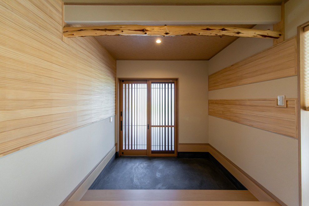 Esempio di un corridoio di medie dimensioni con pareti beige, una porta scorrevole, una porta in legno bruno, pavimento nero e soffitto in perlinato