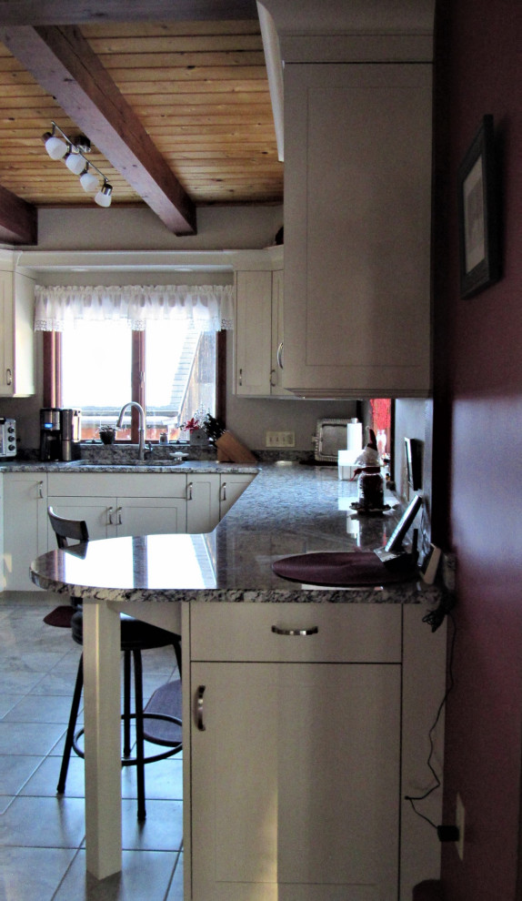 Example of a mid-sized transitional u-shaped eat-in kitchen design in Boston with an undermount sink, shaker cabinets, beige cabinets, granite countertops, stainless steel appliances, a peninsula and gray countertops
