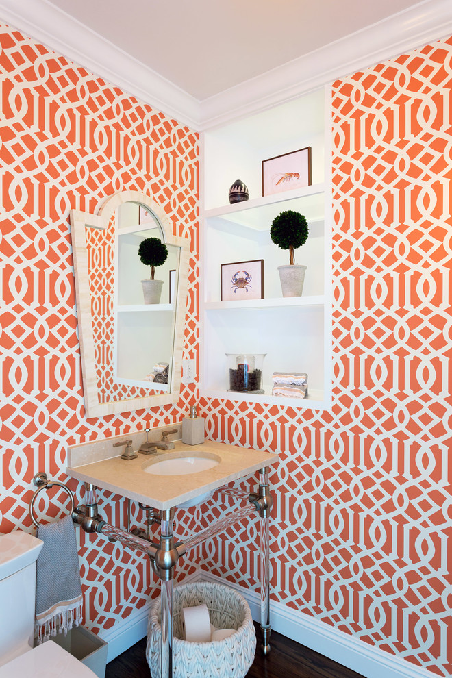 Expansive transitional powder room in Los Angeles with a one-piece toilet, orange walls, dark hardwood floors, a console sink and brown floor.