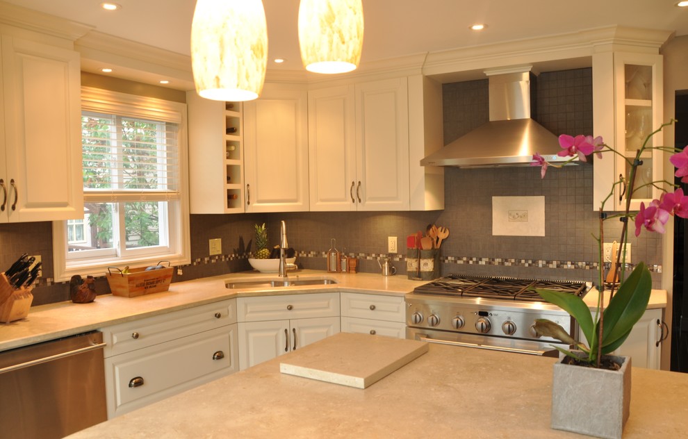 Example of a large transitional l-shaped ceramic tile open concept kitchen design in Ottawa with an undermount sink, raised-panel cabinets, dark wood cabinets, stainless steel appliances and an island