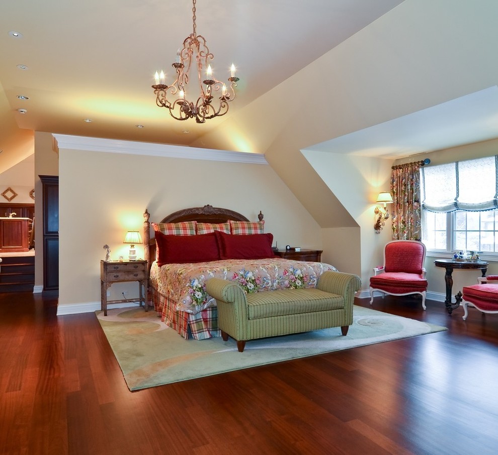 Photo of a large traditional master bedroom in Chicago with yellow walls and medium hardwood floors.