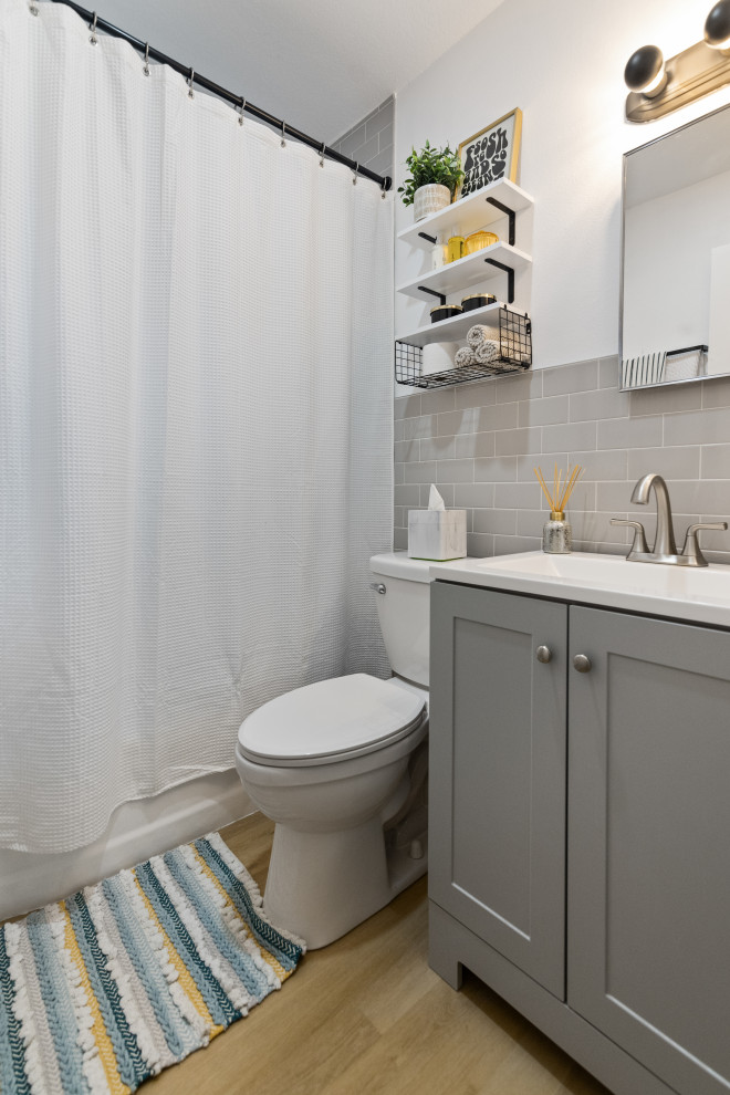 Photo of a medium sized coastal shower room bathroom in Tampa with open cabinets, white cabinets, an alcove shower, a one-piece toilet, white tiles, ceramic tiles, white walls, vinyl flooring, a built-in sink, solid surface worktops, beige floors, a shower curtain, white worktops, a single sink, a floating vanity unit and a drop ceiling.