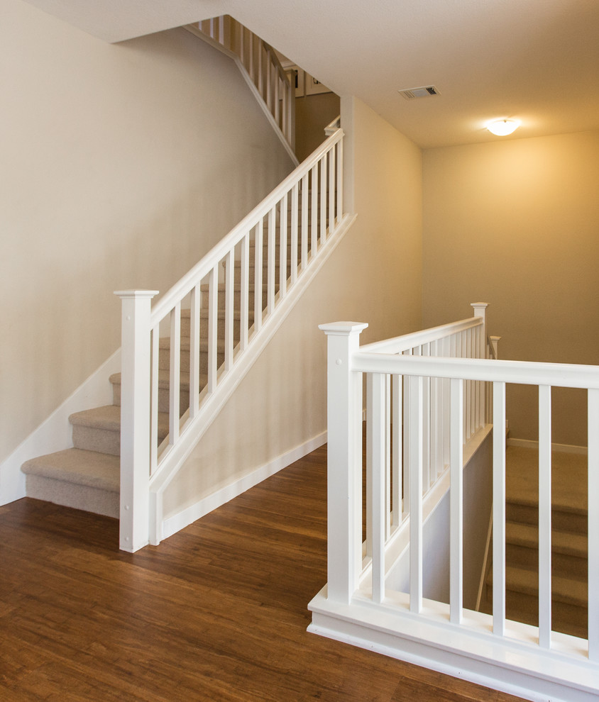 Mid-sized elegant carpeted u-shaped wood railing staircase photo in San Francisco with carpeted risers