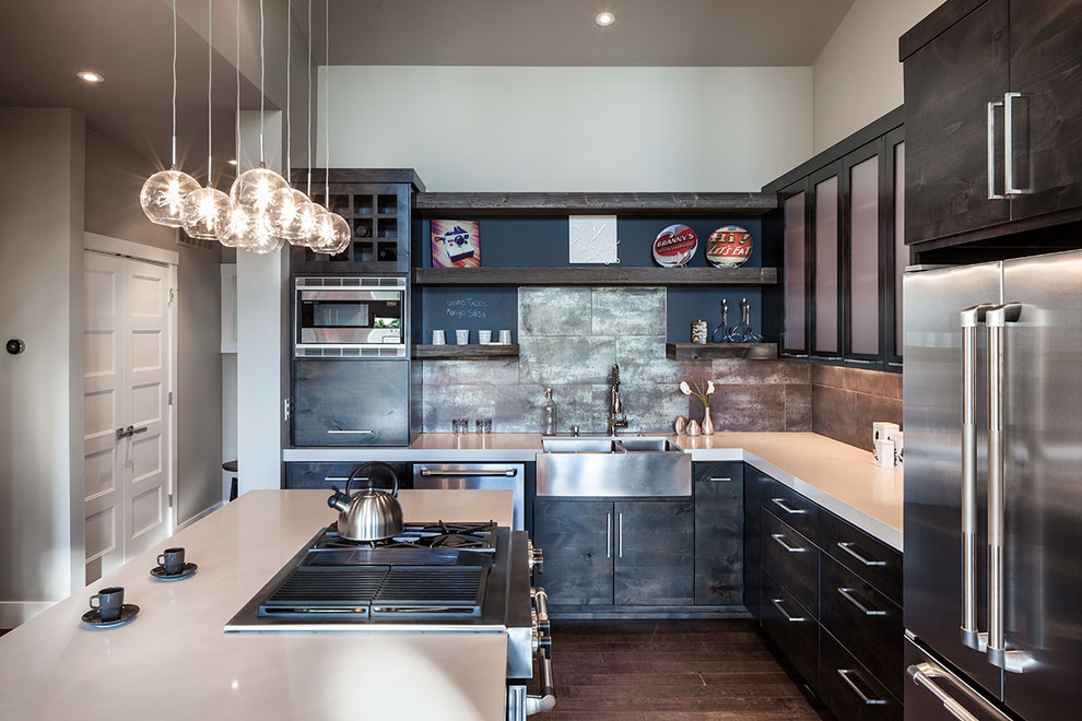 Photo of a large contemporary l-shaped eat-in kitchen in Portland with stainless steel appliances, a farmhouse sink, flat-panel cabinets, dark wood cabinets, quartz benchtops, with island, metallic splashback and dark hardwood floors.