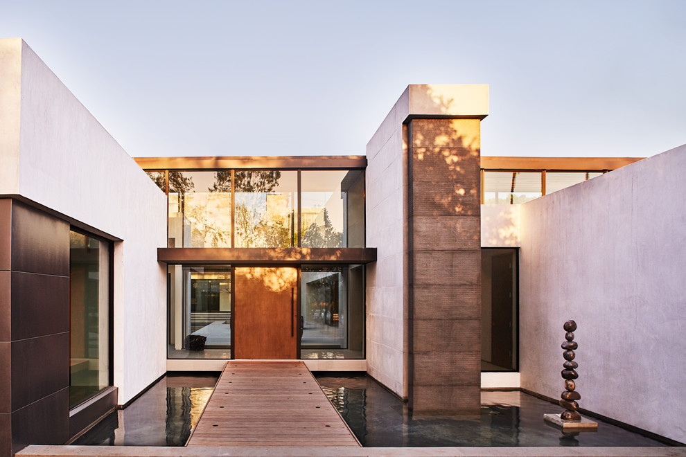 Inspiration for a modern two-storey white house exterior in Los Angeles with a flat roof.