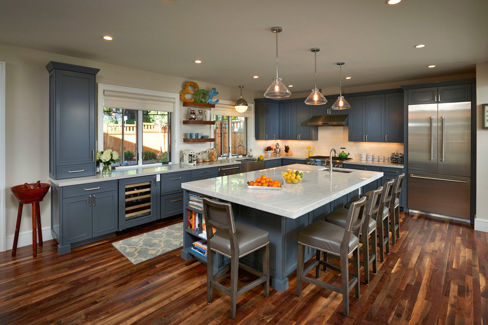 Large transitional l-shaped dark wood floor open concept kitchen photo in Denver with a farmhouse sink, recessed-panel cabinets, blue cabinets, quartz countertops, white backsplash, subway tile backsplash, stainless steel appliances and an island