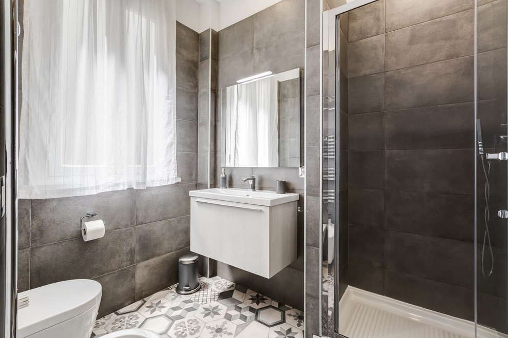 Small contemporary 3/4 bathroom in Rome with flat-panel cabinets, white cabinets, a corner shower, a wall-mount toilet, brown walls, ceramic floors, a wall-mount sink, multi-coloured floor and a sliding shower screen.