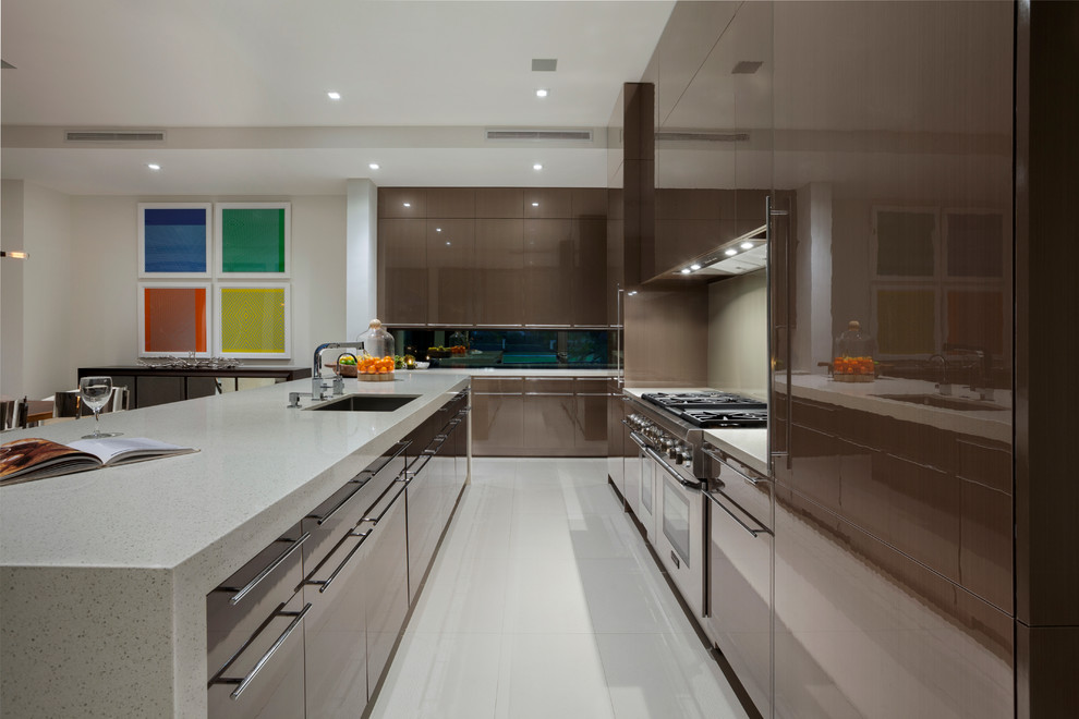 This is an example of a large midcentury l-shaped open plan kitchen in Miami with flat-panel cabinets, quartzite benchtops, glass sheet splashback, porcelain floors, with island and stainless steel appliances.