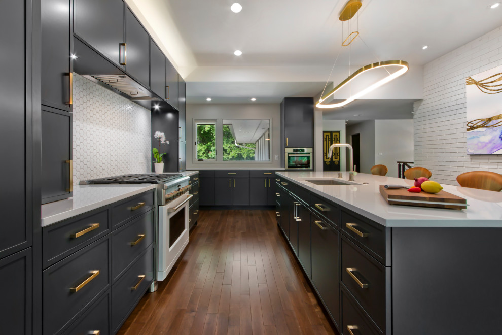 Photo of a large l-shaped kitchen pantry in Minneapolis with an undermount sink, recessed-panel cabinets, black cabinets, quartz benchtops, white splashback, cement tile splashback, panelled appliances, medium hardwood floors, with island and white benchtop.