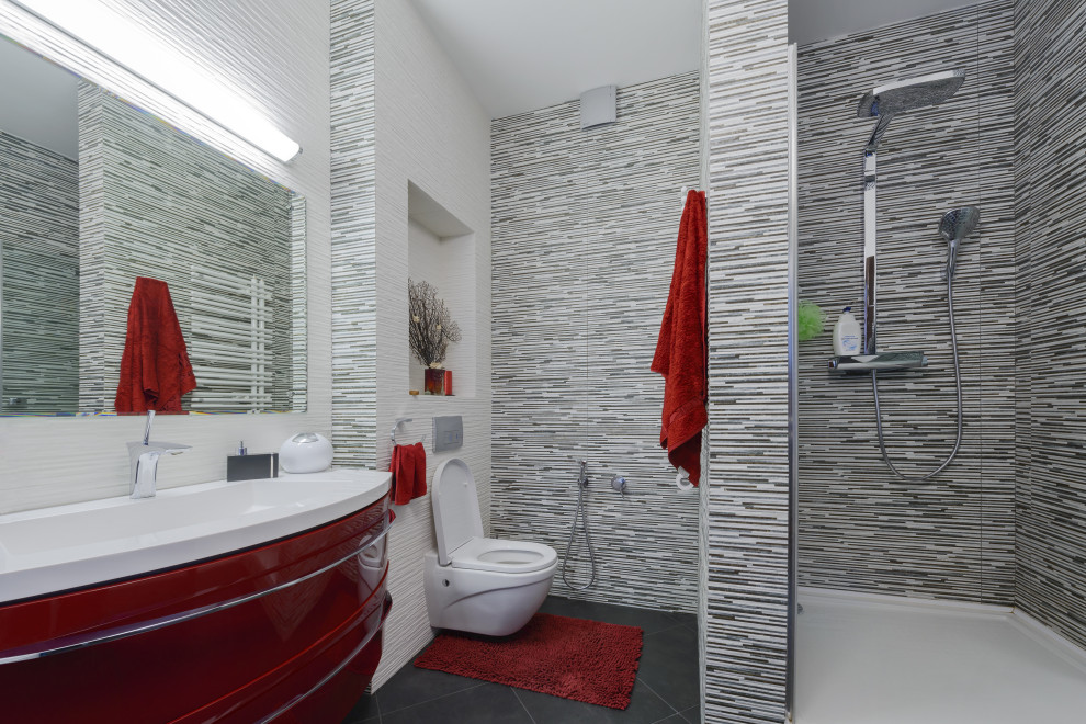 Mid-sized contemporary 3/4 bathroom in Houston with flat-panel cabinets, red cabinets, an alcove shower, a wall-mount toilet, gray tile, matchstick tile, an integrated sink, grey floor and white benchtops.