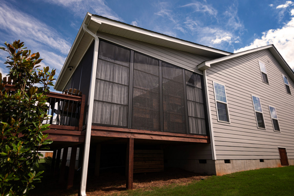 Klassisk inredning av en mellanstor veranda på baksidan av huset, med trädäck och takförlängning
