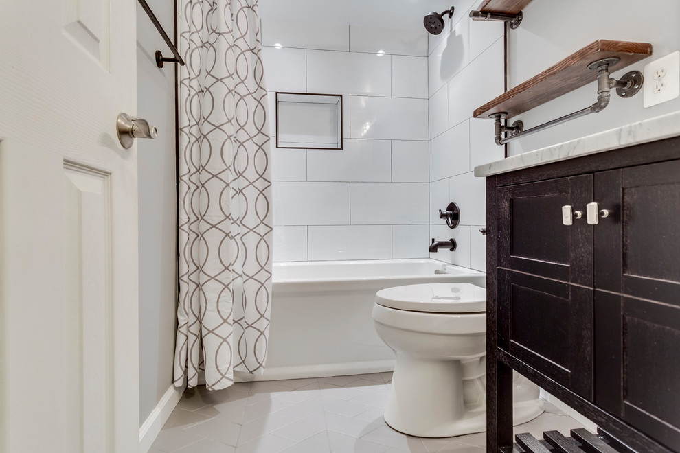 Photo of a small transitional 3/4 bathroom in DC Metro with furniture-like cabinets, dark wood cabinets, an alcove tub, a shower/bathtub combo, a two-piece toilet, white tile, porcelain tile, grey walls, an undermount sink, marble benchtops, white floor, a shower curtain and grey benchtops.