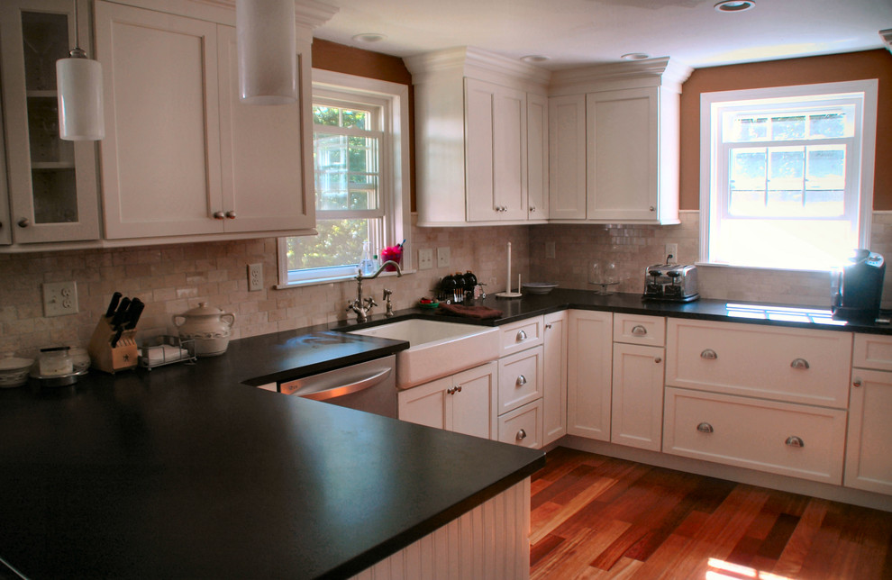 Design ideas for a mid-sized transitional u-shaped eat-in kitchen in Boston with a farmhouse sink, shaker cabinets, white cabinets, granite benchtops, beige splashback, porcelain splashback, stainless steel appliances, medium hardwood floors, a peninsula and red floor.