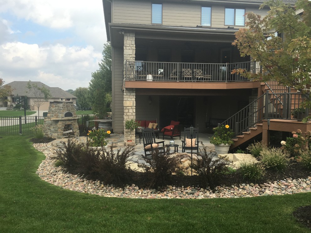 Photo of a large modern backyard partial sun garden in Omaha with a fire feature.