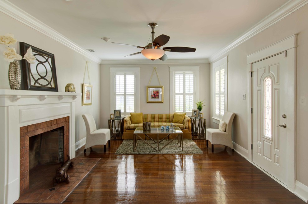 Mid-sized traditional formal open concept living room in Tampa with white walls, medium hardwood floors, a standard fireplace and a brick fireplace surround.