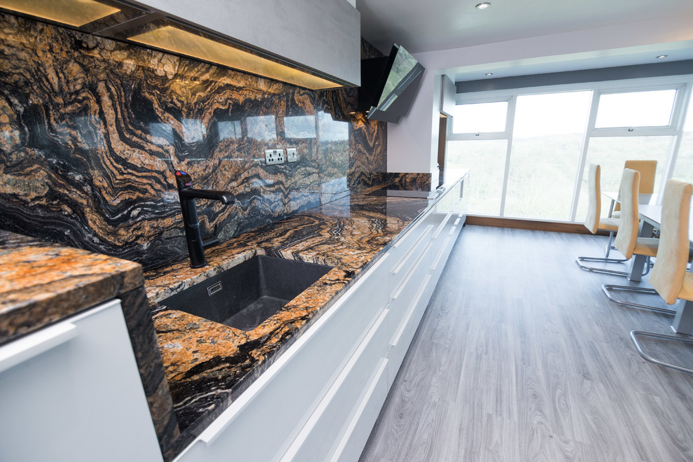 Design ideas for a modern l-shaped open plan kitchen in Other with a drop-in sink, glass-front cabinets, stainless steel cabinets, granite benchtops, multi-coloured splashback, stone slab splashback, stainless steel appliances, vinyl floors, grey floor and multi-coloured benchtop.