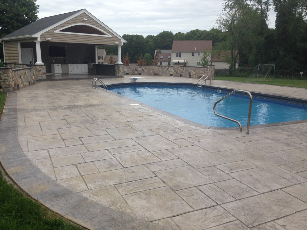 Inspiration for a large traditional backyard rectangular pool in Providence with a pool house and stamped concrete.