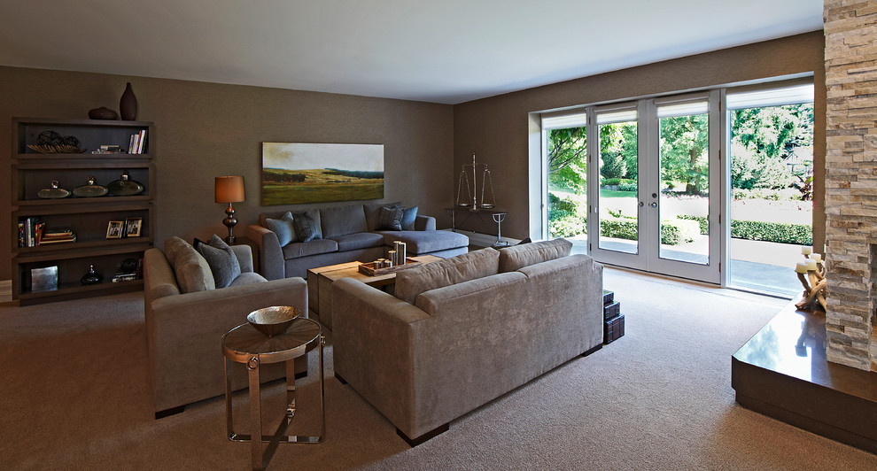 Example of a large transitional walk-out carpeted basement design in Toronto with beige walls, a standard fireplace and a stone fireplace