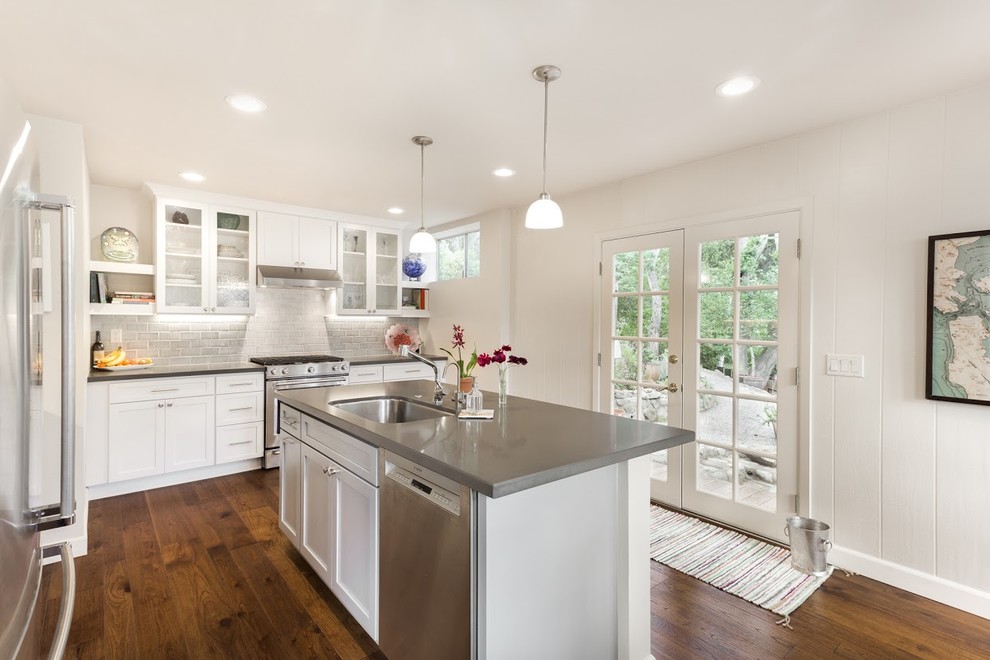 Eat-in kitchen - mid-sized transitional l-shaped medium tone wood floor eat-in kitchen idea with an undermount sink, flat-panel cabinets, white cabinets, quartz countertops, gray backsplash, ceramic backsplash, stainless steel appliances and an island
