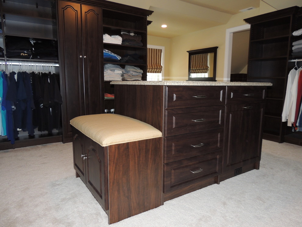 Inspiration for a large traditional gender-neutral walk-in wardrobe in Philadelphia with raised-panel cabinets and dark wood cabinets.