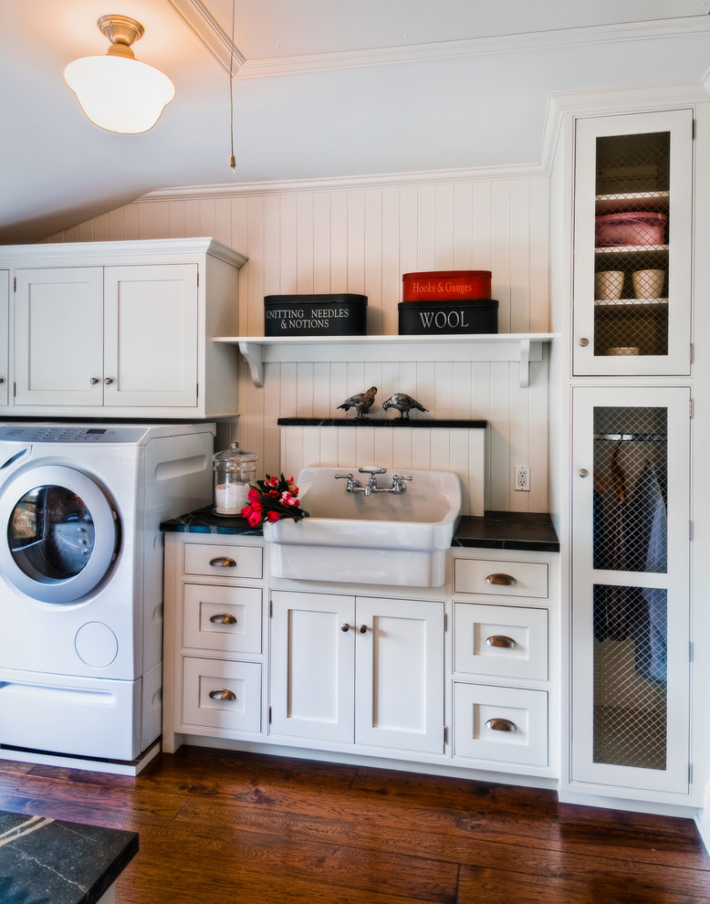 This is an example of a transitional single-wall laundry room in San Francisco with a farmhouse sink, white walls, medium hardwood floors and a side-by-side washer and dryer.