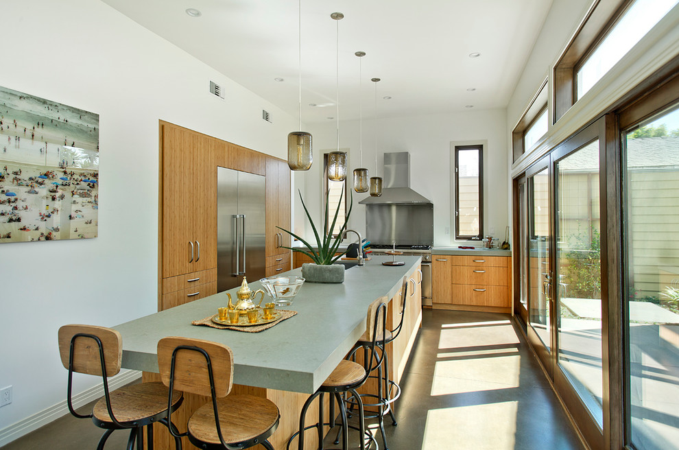 Beach style l-shaped separate kitchen in Los Angeles with flat-panel cabinets, light wood cabinets, quartz benchtops and stainless steel appliances.