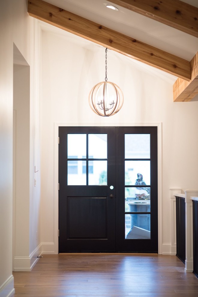 Mid-sized transitional u-shaped medium tone wood floor eat-in kitchen photo in Seattle with a double-bowl sink, raised-panel cabinets, white cabinets, soapstone countertops, white backsplash, stone slab backsplash, stainless steel appliances and an island