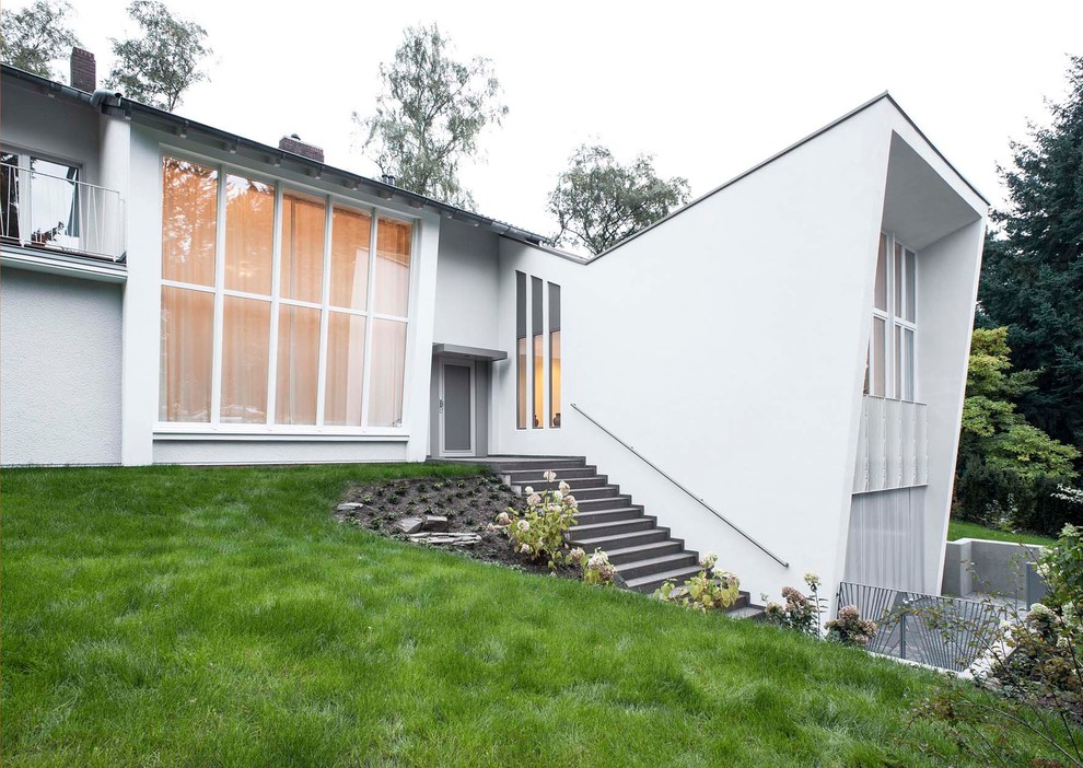 Inspiration for a large contemporary two-storey white exterior in Cologne with a shed roof.