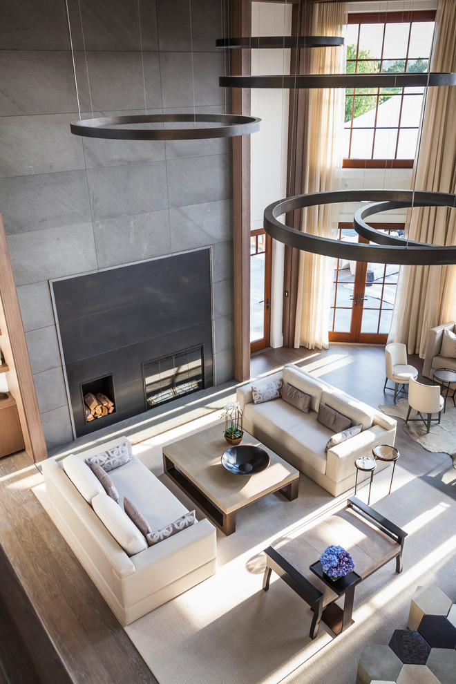 Photo of an expansive contemporary formal open concept living room in New York with white walls, medium hardwood floors, a standard fireplace, a metal fireplace surround, no tv and grey floor.