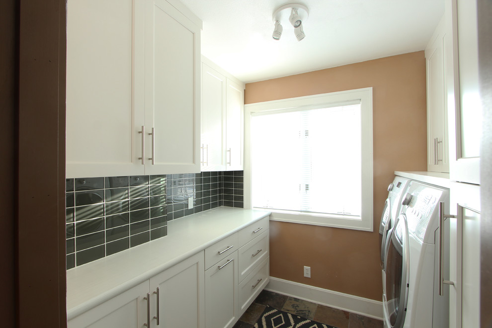 This is an example of a small transitional galley dedicated laundry room in Other with recessed-panel cabinets, white cabinets, laminate benchtops, beige walls, slate floors, a side-by-side washer and dryer and multi-coloured floor.