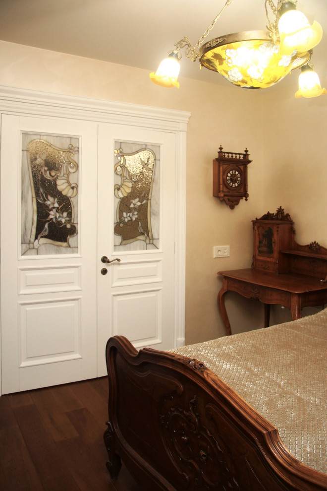 Cette image montre une chambre parentale blanche et bois victorienne de taille moyenne avec un mur beige, parquet foncé et un sol marron.