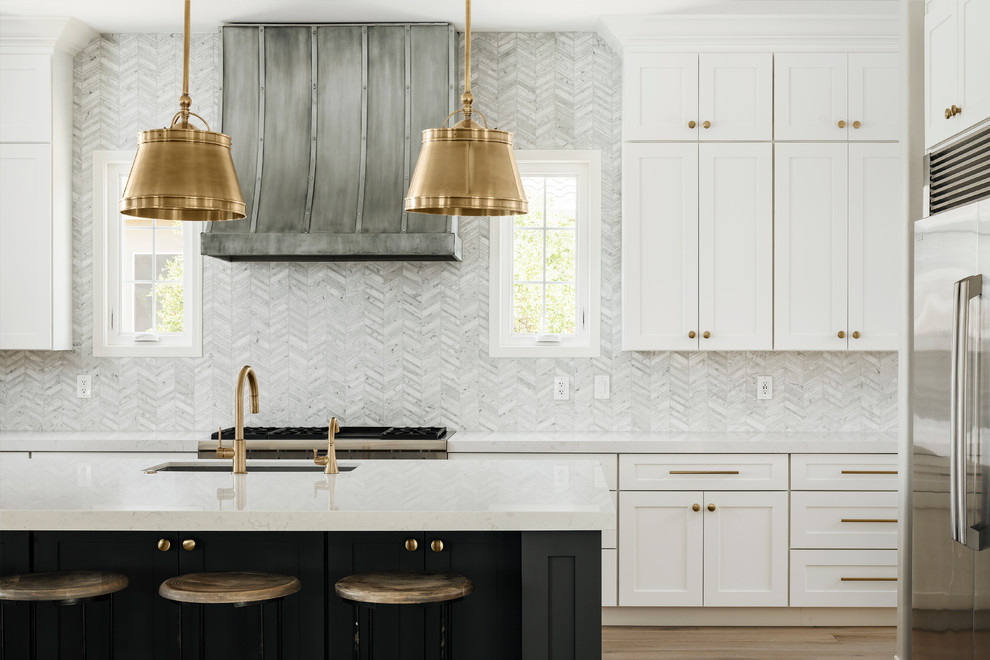Open concept kitchen - large modern l-shaped light wood floor and beige floor open concept kitchen idea in Phoenix with an undermount sink, shaker cabinets, white cabinets, quartz countertops, gray backsplash, marble backsplash, stainless steel appliances, an island and white countertops