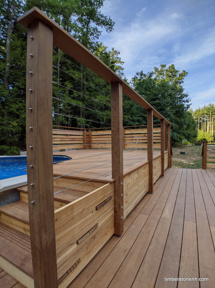 Inspiration for a large modern backyard deck in Manchester with a pergola and mixed railing.