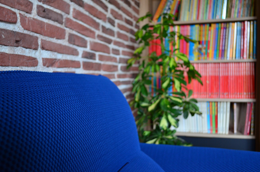 Exemple d'un salon industriel avec un mur en parement de brique, une bibliothèque ou un coin lecture et parquet clair.