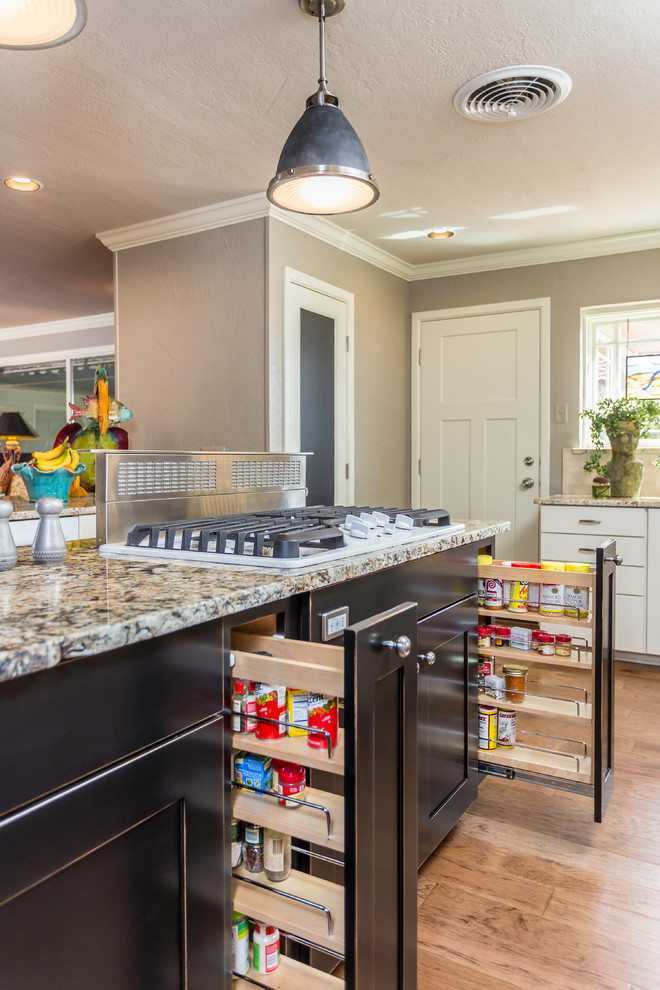 Example of a large transitional u-shaped medium tone wood floor kitchen pantry design in Dallas with an undermount sink, shaker cabinets, black cabinets, granite countertops, white backsplash, stone tile backsplash, white appliances and an island