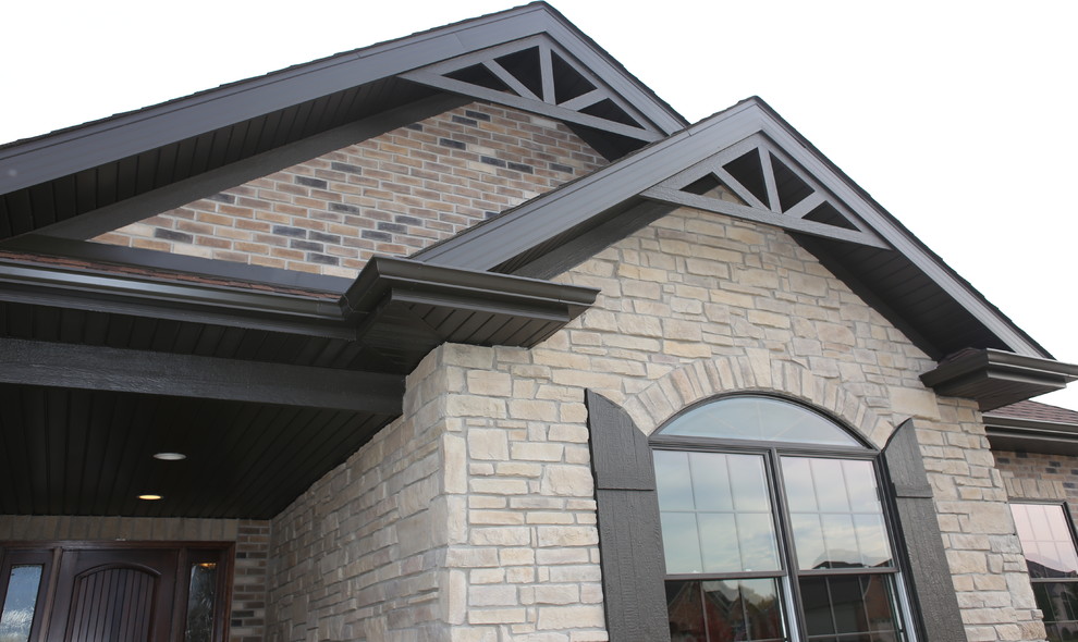 Inspiration for a mid-sized country one-storey brown exterior in Chicago with stone veneer and a hip roof.