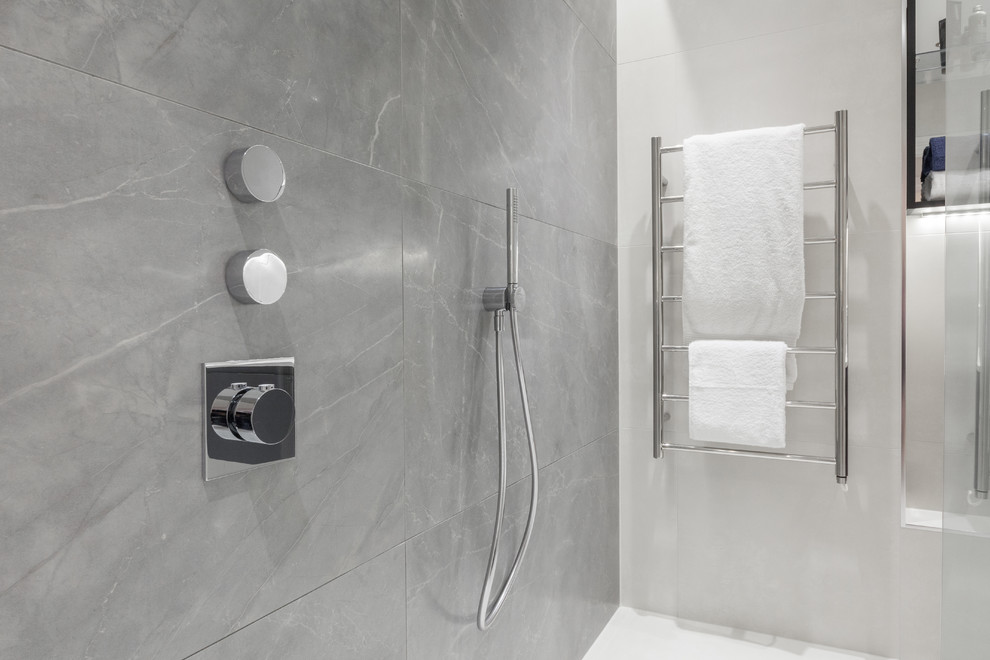 Inspiration for a medium sized contemporary shower room bathroom in Oxfordshire with glass-front cabinets, brown cabinets, a walk-in shower, a wall mounted toilet, grey tiles, marble tiles, grey walls, porcelain flooring, a wall-mounted sink, quartz worktops, grey floors and an open shower.