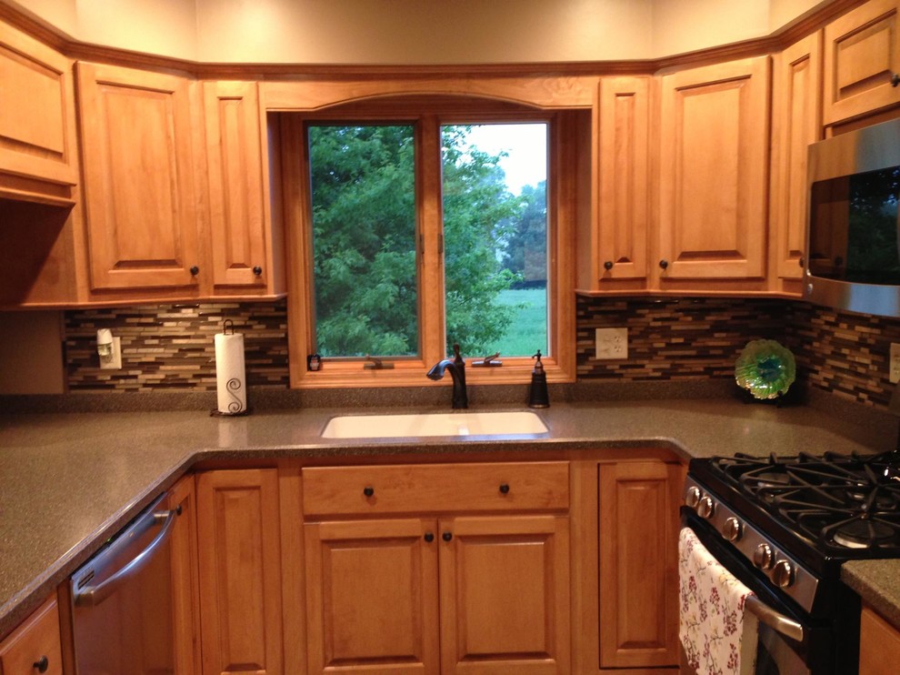 Photo of a small u-shaped separate kitchen in Chicago with an undermount sink, raised-panel cabinets, medium wood cabinets, brown splashback, matchstick tile splashback and no island.