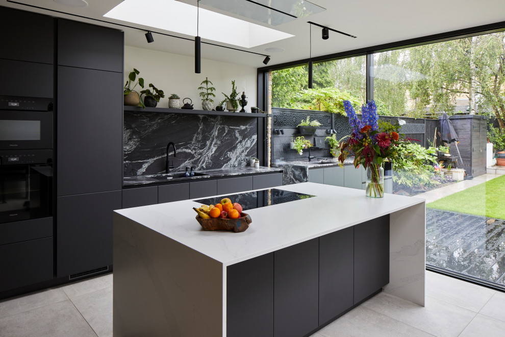 Medium sized contemporary single-wall open plan kitchen in London with flat-panel cabinets, black cabinets, engineered stone countertops and an island.