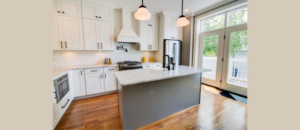 Inspiration for a mid-sized transitional l-shaped medium tone wood floor eat-in kitchen remodel in DC Metro with shaker cabinets, white cabinets, marble countertops, white backsplash, subway tile backsplash, stainless steel appliances, an island and a farmhouse sink