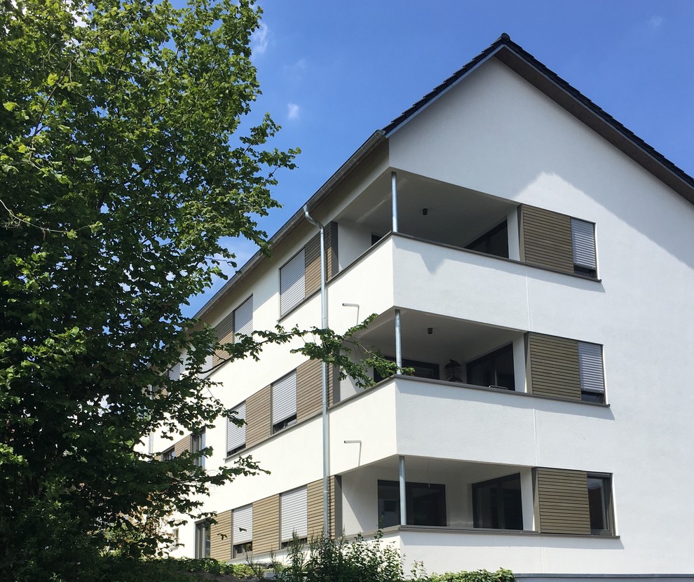 Großes, Zweistöckiges Modernes Einfamilienhaus mit Putzfassade, weißer Fassadenfarbe, Halbwalmdach und Ziegeldach in München