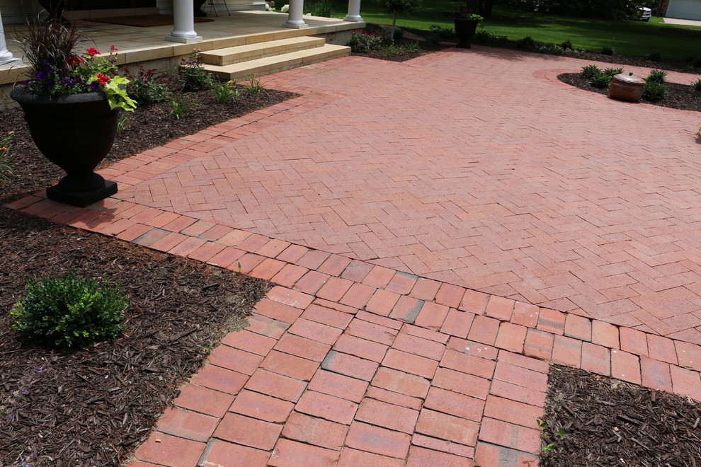 Photo of a mid-sized traditional front yard patio in Chicago with brick pavers and no cover.