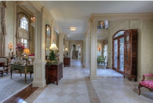 Photo of an expansive traditional foyer in Las Vegas with beige walls, travertine floors, a double front door and a medium wood front door.