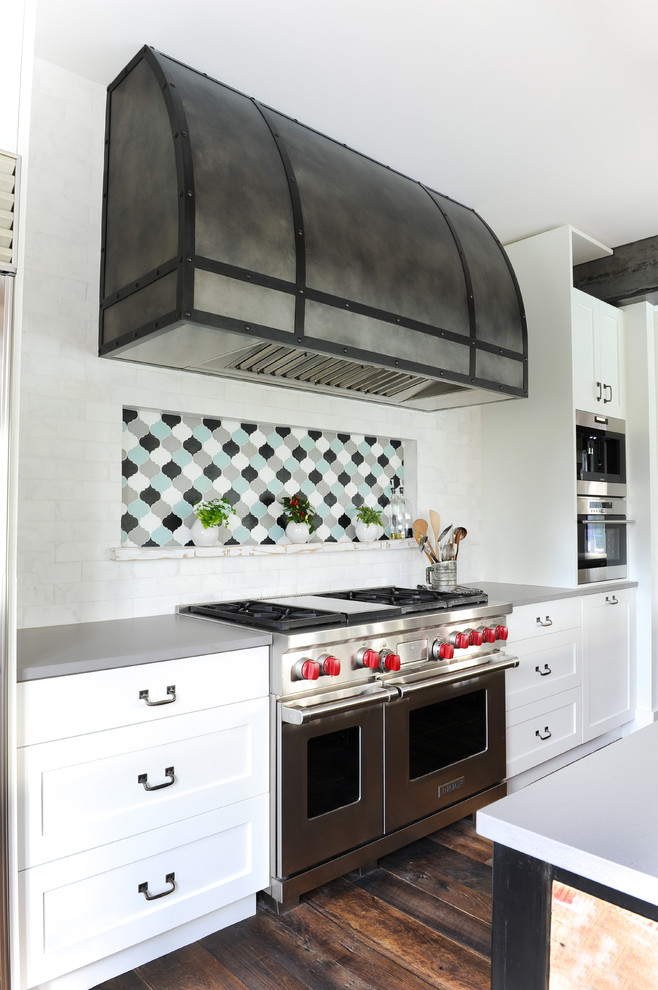 Inspiration for an expansive country l-shaped eat-in kitchen in Vancouver with an undermount sink, white cabinets, stainless steel appliances, dark hardwood floors, with island, brown floor, shaker cabinets, quartz benchtops, white splashback and subway tile splashback.
