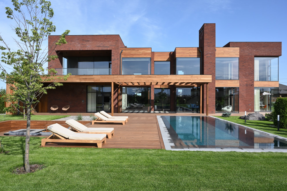 Пример оригинального дизайна: большой, двухэтажный, кирпичный, коричневый дом в современном стиле с плоской крышей